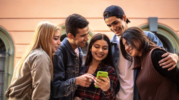 Teenager friends using the mobile phone outdoors