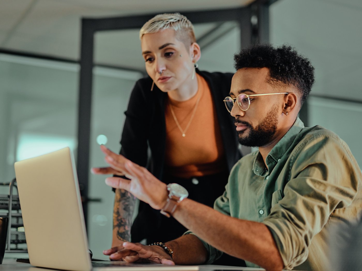 Shot of two young designers working together on a laptop in an office at night