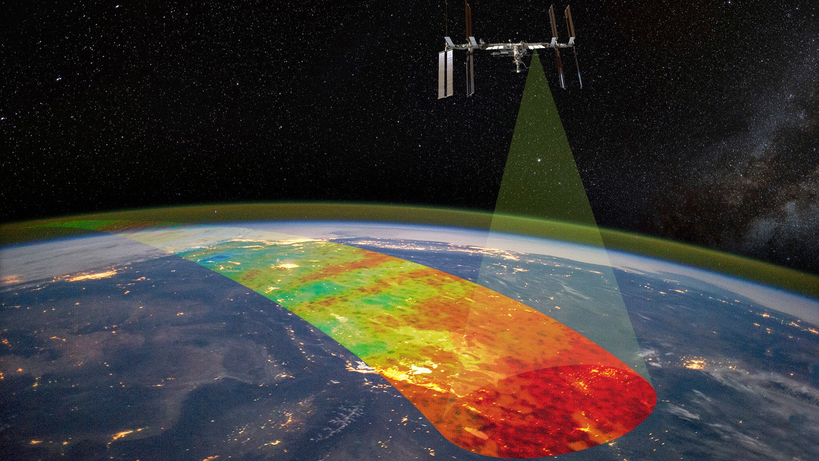 Above Earth, the International Space Station orbits. From one area toward the middle of the station, a transparent cone highlights a rainbow stripe of Earth's atmosphere.