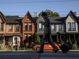 A person walks by a row of houses in Toronto.