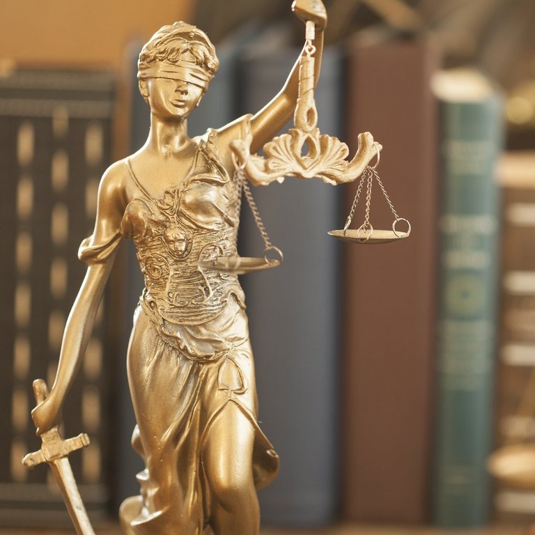 Justitia vor Bücher und Gesetzeswaage