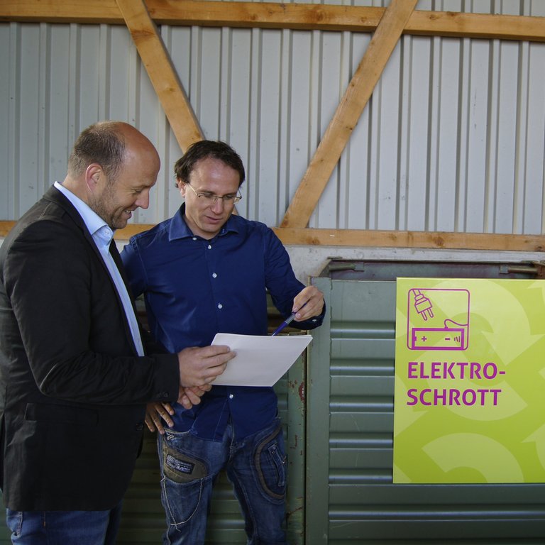 Roland Habermacher und Ueli Maas von Swissrecycling sind auf einer Sammelstelle und beraten sich