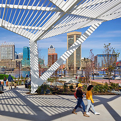 A group of people walking under a glass roof.