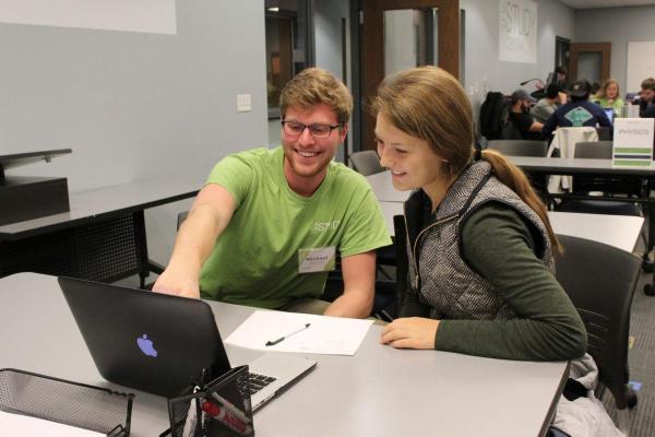 Tutor working with student using laptop