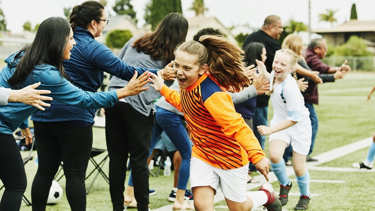 Billede af forældre der giver børn high five efter en fodboldkamp