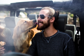 Ein Hund, der das Gesicht eines Mannes leckt