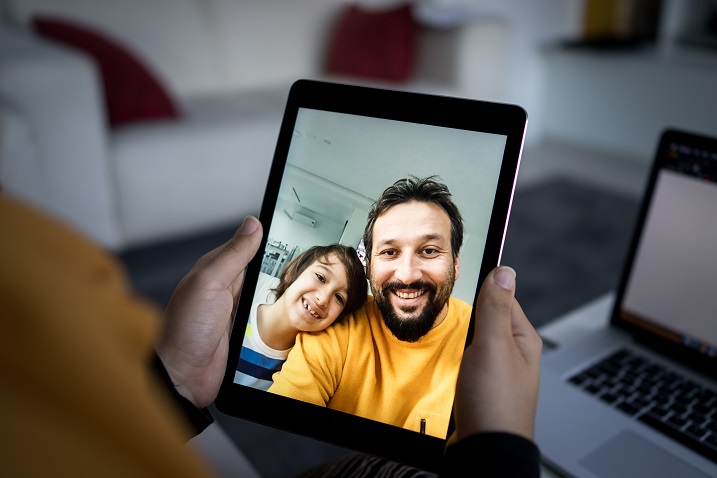 photo of a person holding a tablet device with a video call going on