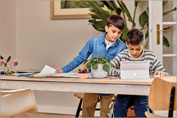 Microsoft Surface 장치를 보고 있는 어린 두 학생