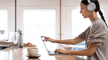 Een vrouw die een Surface Laptop gebruikt op een bureau