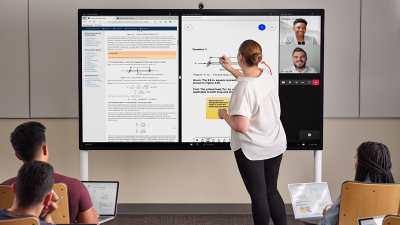 Um professor está na frente de uma classe incrustando em um Hub 85" com uma Surface Pen cinza claro. Edge, Whiteboard e Teams estão na tela. Em primeiro plano, vários alunos têm um Pro 7+ e estão fazendo anotações no One Note.