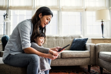 Uma mãe com sua jovem filha olhando para o celular