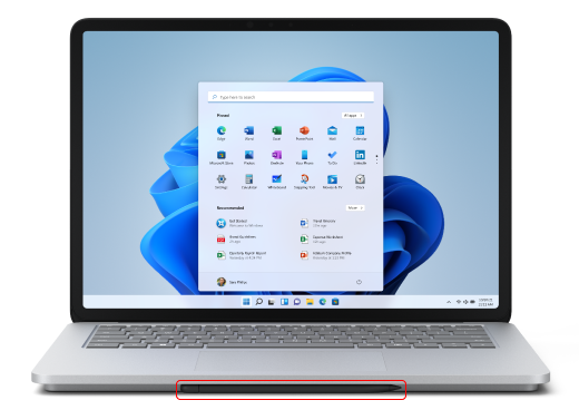 Ручка Surface Slim 2 в области зарядки под трекпадом Surface Laptop Studio.
