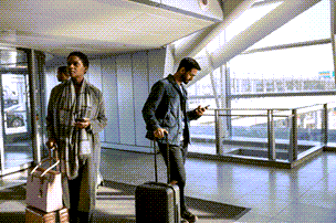 Personer på en flygplats som kontrollerar sina trådlösa enheterna.